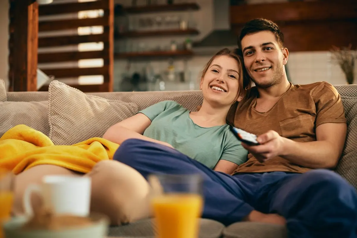 Un couple regarde un film grâce à son abonnement IPTV Smarters sur Smart TV dans le salon